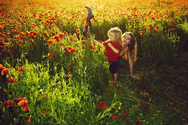 Meisje en kleine jongen of kind op gebied van papaver — Stockfoto