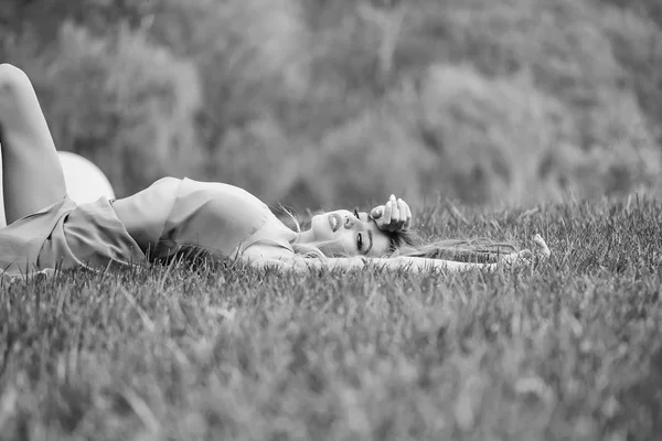 Vrouw liggend op groen gras — Stockfoto