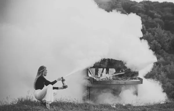 Hašení požáru dívka s hasicí přístroj. Hasičské s žena držící hasicí přístroj venku v bílý kouř. — Stock fotografie