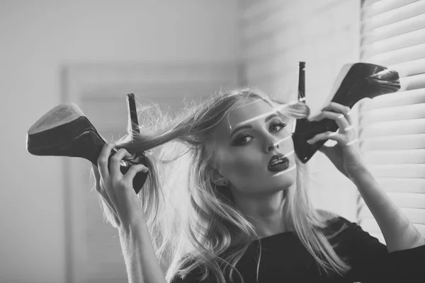 Glamour sinnliche Frau mit blonden langen Haaren hält Schuhe — Stockfoto