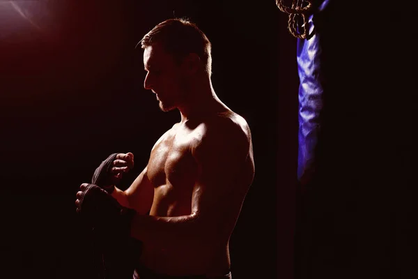 Conceito de kickboxing. O homem musculoso prepara-se para o kickboxing. Esportista apto a ir para o ginásio de kickboxing. Exercício de kickboxing. Luvas para cima — Fotografia de Stock