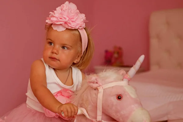 Eu e o meu cavalo. Criança pequena usar faixa de cabelo. Pequena menina loira montar brinquedo cavalo. Menina com penteado longo. Acessório de cabelo. Penteado infantil para meninas. Estilo de bebê fácil — Fotografia de Stock