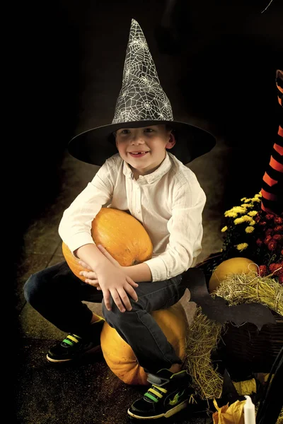 Halloween bambino in cappello da strega con zucca gialla — Foto Stock