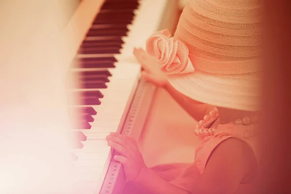 Kid in vintage pink hat, dress, bead necklace play piano — Stock Photo, Image