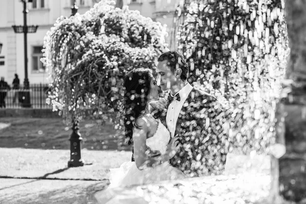 Hochzeitspaar küsst sich in der Nähe von Brunnenwasser — Stockfoto