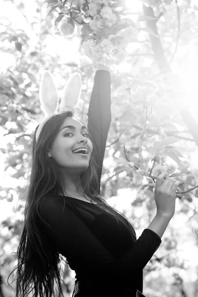 Meisje glimlachend met schattige bunny oren bij sakura tree — Stockfoto