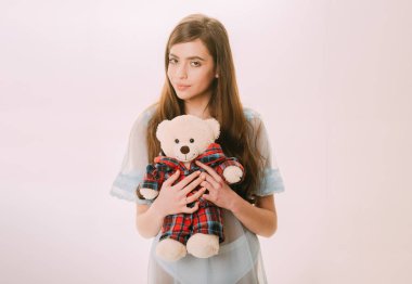 Sağlıklı ve sakin bir uyku için. Güzel kız tutun oyuncak ayı oyuncak. İpeksi Geceliği veya pijama ile yumuşak oyuncak sevimli kız. Genç kız uyuyacak. Genç kadın giyiyor Geceliği iç çamaşırı