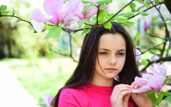 Jovens e frescos. É tempo de primavera. Menina adorável jogar no parque com flores florescentes. Menina bonita perto de árvore florida desfrutar de flor de magnólia. Menina bonito relaxar na paisagem primavera — Fotografia de Stock