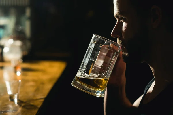 Něco k pití, nebo dva po práci. Alkohol narkoman s korbelem piva. Člověk pije v hospodě. Pohledný muž pít pivo v baru. Pivní restaurace. Závislost na alkoholu a zlozvyk. Návykový alkoholický nápoj — Stock fotografie