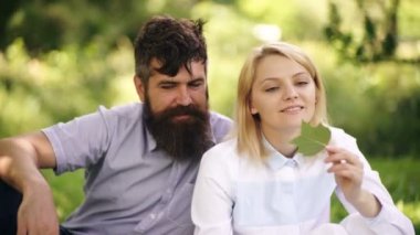 Happy Smiling Couple Relaxing on Green Grass. Park.Young Family Lying on Grass Outdoors. Healthcare, freedom, love concept.