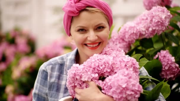 Mujeres con flores. Las mujeres cuidan las flores. 4k. Mujeres felices en el jardín de flores. Mujer disfruta de flores . — Vídeos de Stock