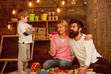 Oyuncak kavramı. Anne ve baba ile oğlu inşa yapısı ile oyuncak inşaat ayarlayın. Çocuklar için eğitici oyuncak. Küçük çocuk oyuncak tuğla ile oynamak