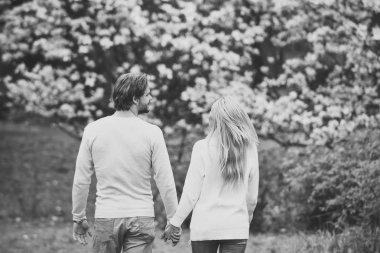 Şehvetli çift el Bahar park, arkadan görünüm tutmak.