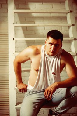 Genç adam merdivene otur. Genç adam trendy kolsuz bluz ve kot pantolon