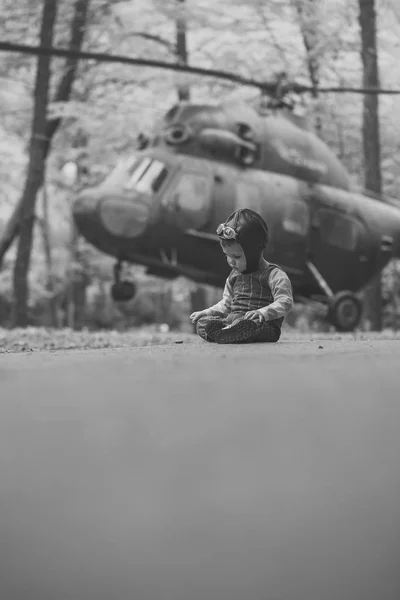 Niño sentado en helicóptero sobre fondo natural — Foto de Stock