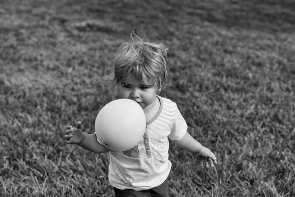 Baby pojke leker med rosa leksak ballong — Stockfoto