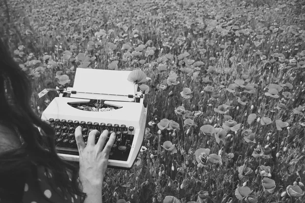 Impresiones de manos humanas en una máquina de escribir retro en el campo de la amapola —  Fotos de Stock