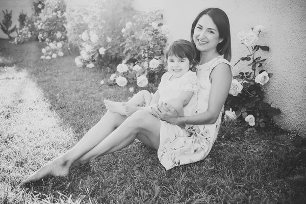 Femme avec bébé fille assis sur l'herbe verte — Photo