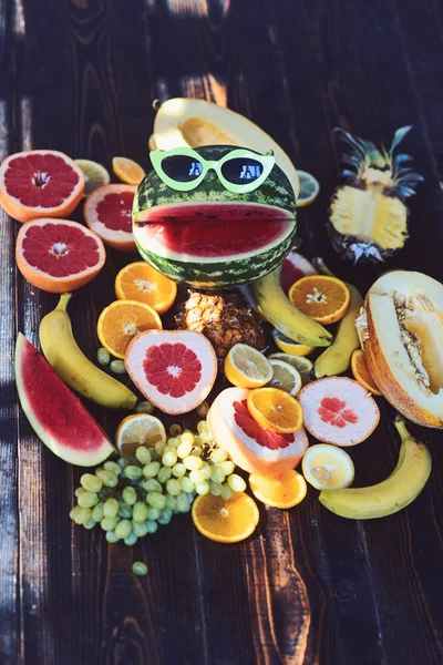 Pastèque dans des lunettes de soleil drôles avec le sourire. Fruits frais nature morte sur table en bois. Aliments végétariens pour le régime de désintoxication et la santé. Régime vitaminique et nutrition. Concept vacances d'été — Photo