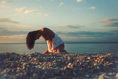 şehvetli kız seksi vücut ile kumsalda sakin ol. Seksi kadın oturup günbatımı kum ile çıplak göğüs üzerinde. Yaz tatili ve cennet tatil seyahat. deniz gündoğumu çıplak kadın. Doğa ve çevre