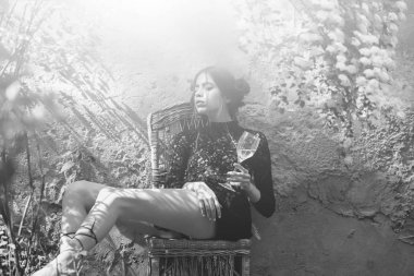 kapalı gözler ve cam sandalyede oturan kadın ile