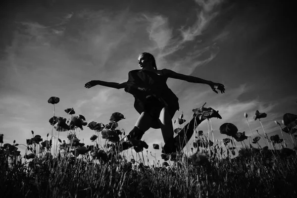 Модель красоты или прыгающая девушка в цветочном поле мака — стоковое фото