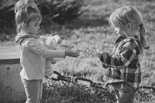 Girl with toy play with boy on natural background — Stock Photo, Image