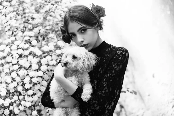 Femme tenir chien avec maquillage espagnol, rose dans les cheveux — Photo