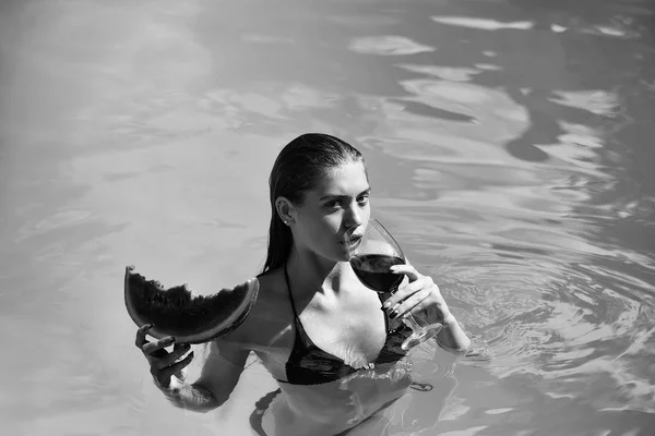 Mulher com melancia e vinho na piscina — Fotografia de Stock