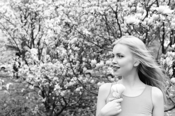 Ung vacker kvinna nära magnoliaträd med blommor — Stockfoto