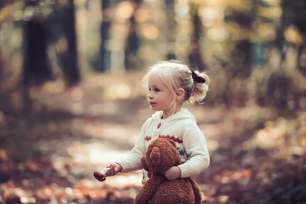 Malá holčička s hračkou mít na podzim park — Stock fotografie