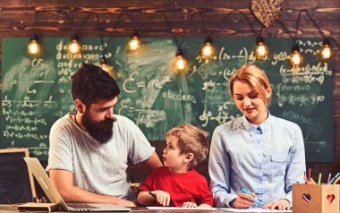 Anne ve baba ile oğlu masa başında oturmak. Keçeli kalem kağıt üzerinde aile boya. Kadın ve adam boyama küçük çocuk çalışma. Çizim birlikte keyfini çıkarın. Yaratıcılık ve geliştirme