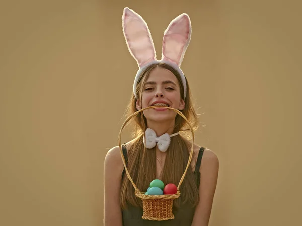 Пасхальная девушка с кроличьими ушами и луком на бежевом фоне — стоковое фото