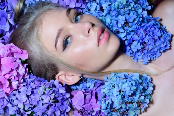 Mujer de primavera con flores de hortensias. chica con maquillaje de verano. Belleza de verano. Retrato de mujer de moda. Cabello y piel sanos. Maquillaje cosmético y cuidado de la piel. Soy un manantial — Foto de Stock