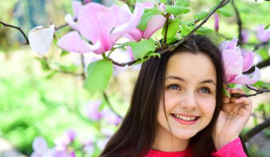 Spring freshness. Pretty girl near flowering tree enjoy magnolia blossom. Its spring time. Adorable girl smile in park with blossoming flowers. Cute girl happy smiling on spring landscape