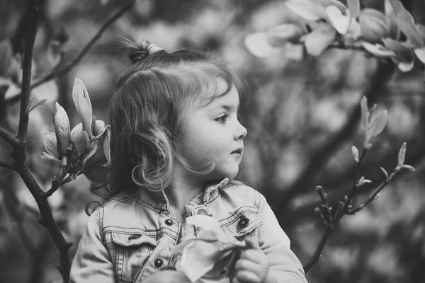 Liten flicka i blommande trädgård vårdag — Stockfoto