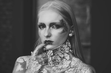 Sarı saçlı, altın folyo deri, kozmetik kızla.