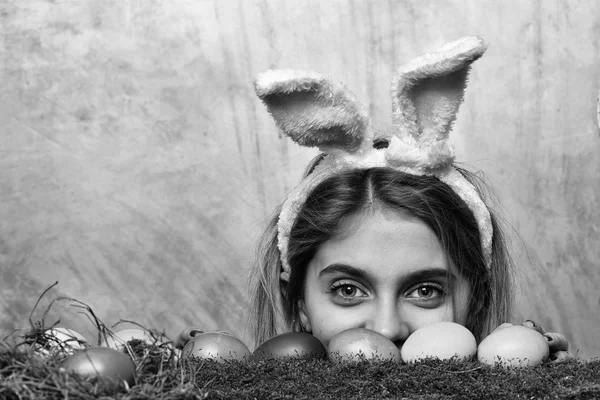 Feliz chica de Pascua en orejas de conejo con huevos de colores, musgo — Foto de Stock