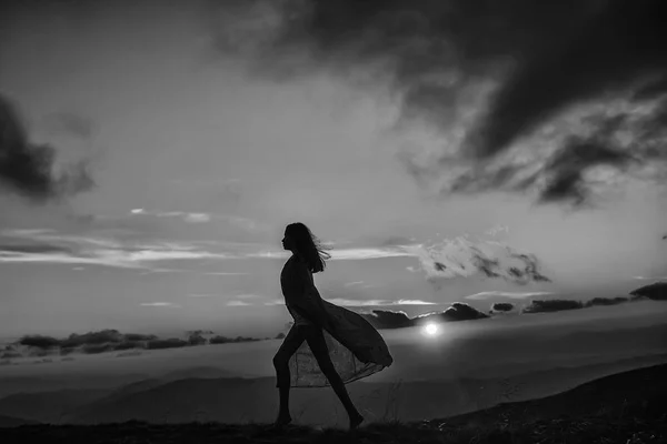 Женщина на закате или восходе солнца в горах — стоковое фото