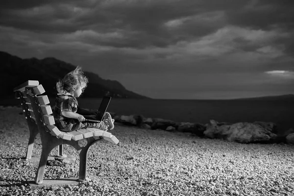 Mignon garçon avec ordinateur portable sur la plage — Photo