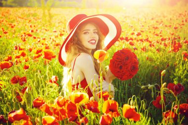 Kırmızı haşhaş alanındaki şapkalı güzel gülümseyen kız