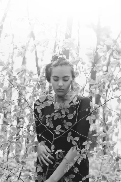 Adorabile ragazza che si nasconde in foglie di albero verde nella foresta primaverile — Foto Stock