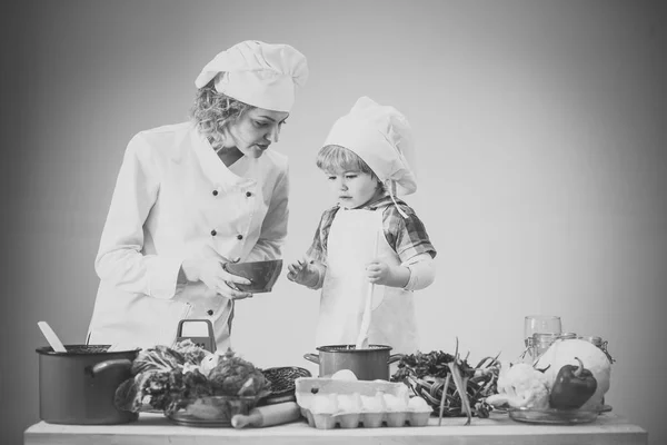 Chef e assistente perto de equipamentos de cozinha e produtos alimentares . — Fotografia de Stock