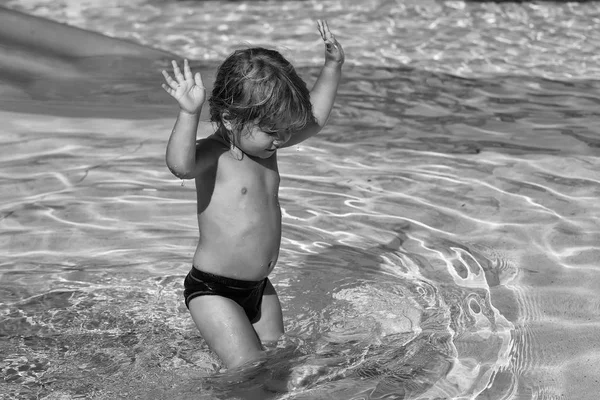 Feliz bebé lindo juega en el tobogán de agua amarillo — Foto de Stock