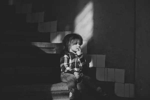 Niño con cara de pensar sentarse en las escaleras de la casa —  Fotos de Stock