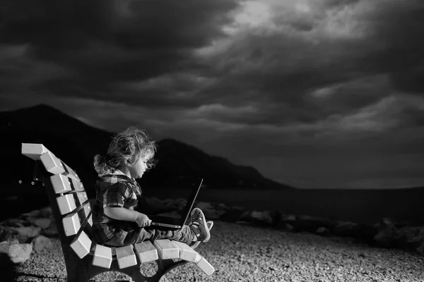 Mignon garçon avec ordinateur portable sur la plage — Photo