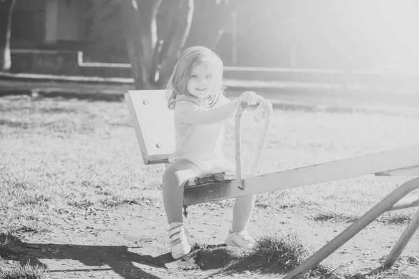 Dívka úsměv na houpačce na slunečný den — Stock fotografie