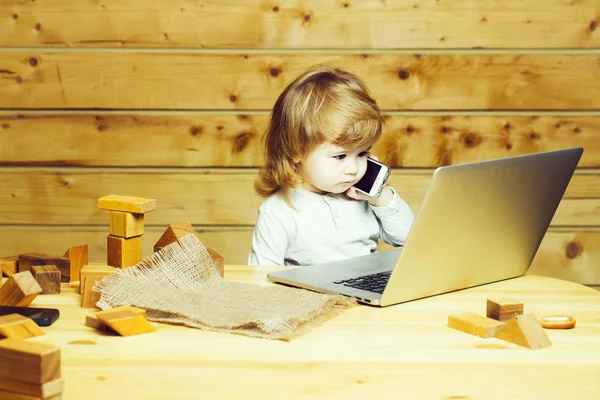 Kleine jongen met computer en telefoon — Stockfoto