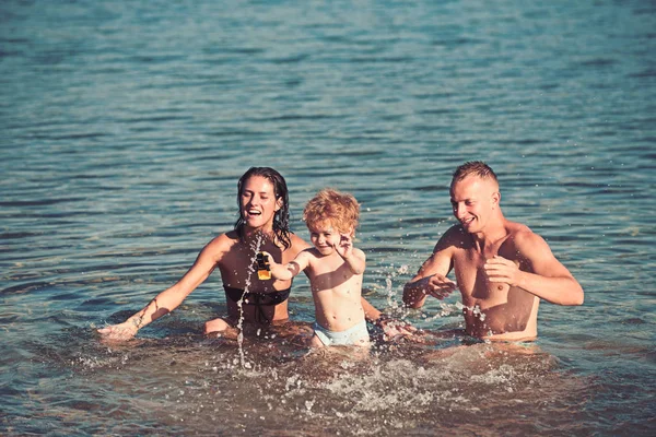 Kind mit Vater und Mutter. Kind spielt mit Eltern im Wasser. — Stockfoto