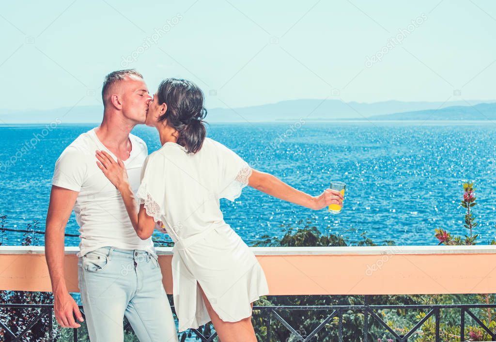 Couple in love relax on balcony. Morning time of sexy woman and man at sea resort. Family and valentines day. Summer holidays and travel vacation. Love relations of couple enjoying fresh juice